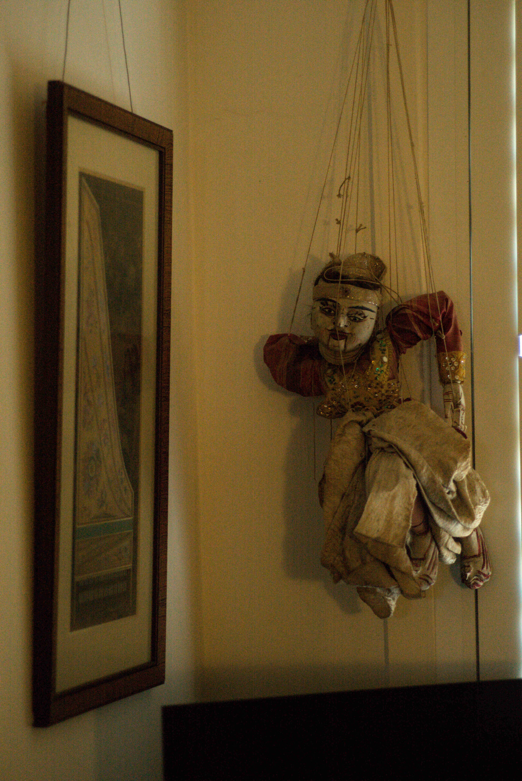 Beauty Everyday, 17: Interior wall with framed artwork and a marionette-style puppet.