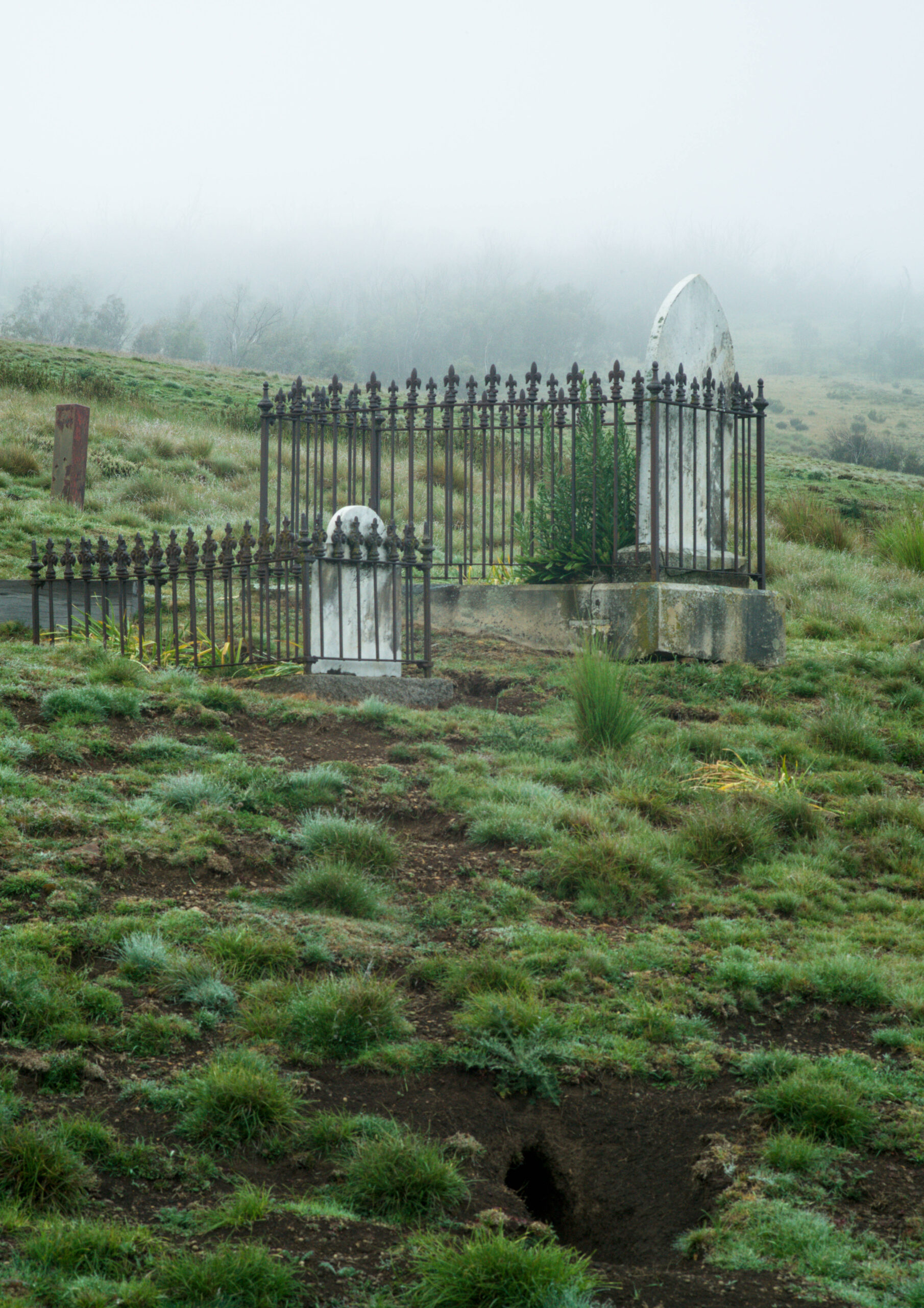 Remains, 4: Two matching graves, one adult and one child, above a rabbit hole in the hillside.