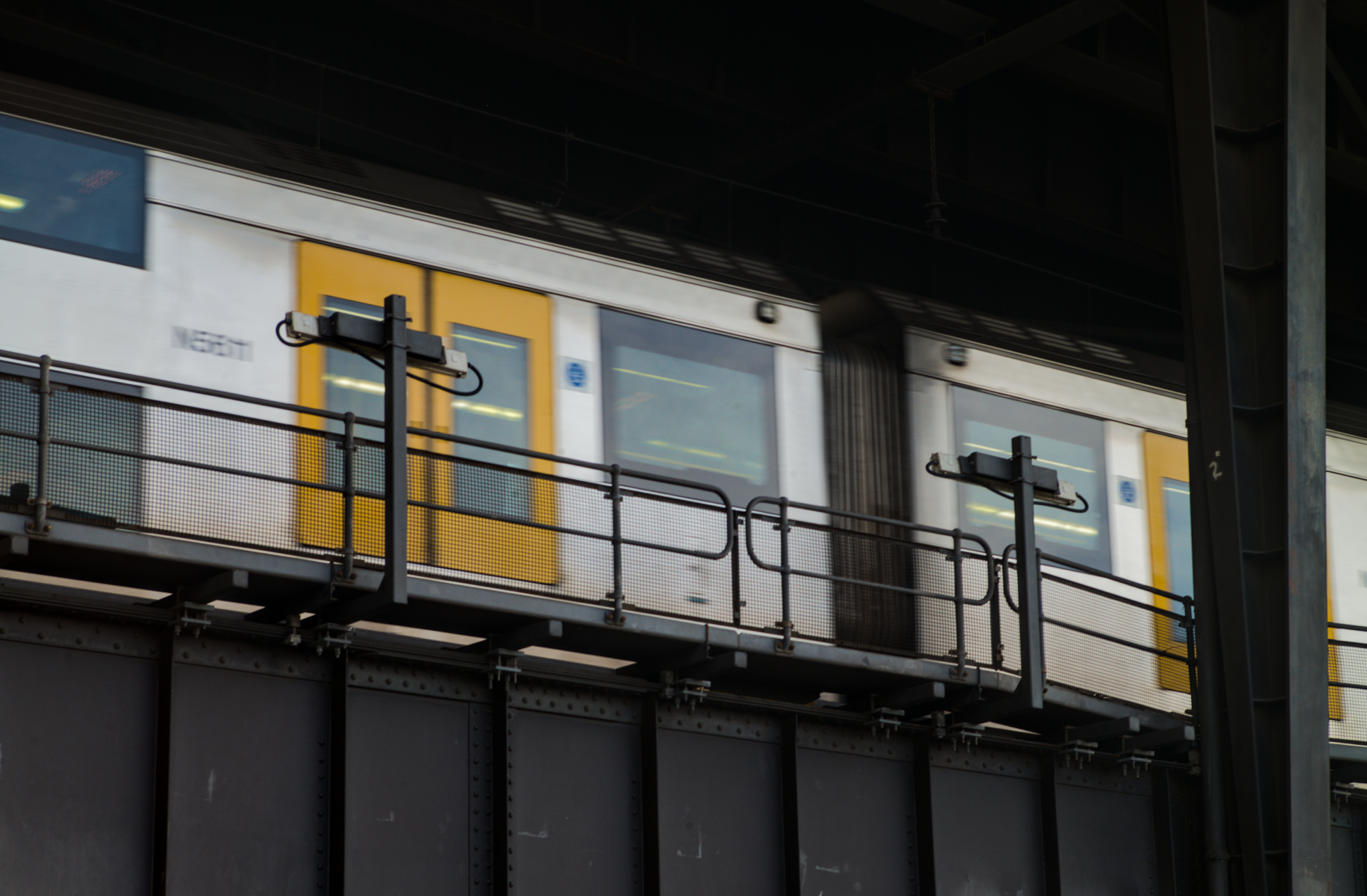 No Turning, 1 - Circular Quay: Train carriages move into station on raised rail line above.